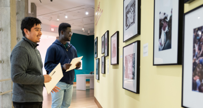 Two visitors look at photographs in "Off-Beat: Portraiture and Politics in the Photography of Gerald Annan-Forson"