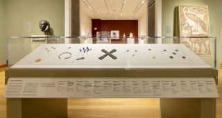 A museum gallery with a case of ancient coinage and other forms of money.