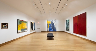 A museum gallery with white walls and six large contemporary abstract works hanging.