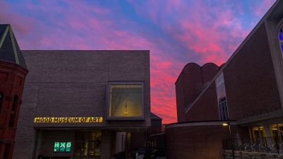 A brilliant pink, purple, and blue sunset sky sets behind the museum.