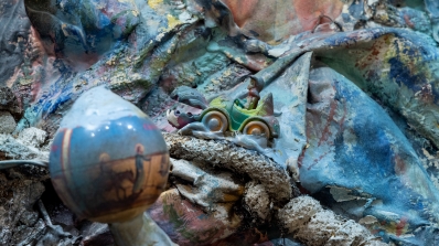 A detail of a sculptural 3D painting that employs cloth, paint, and various found objects.