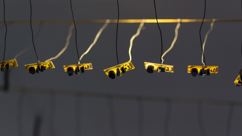 Fig. 11. Laura Maes handmade each unique circuit board and soldered them to the brass rods to create Spikes, 2017, Cummings Hall, Thayer School of Engineering. Photo by Joseph Beaudoin. 