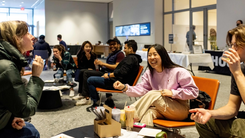 College students sit around table laughing in the Hood Museum's Russo Atrium.