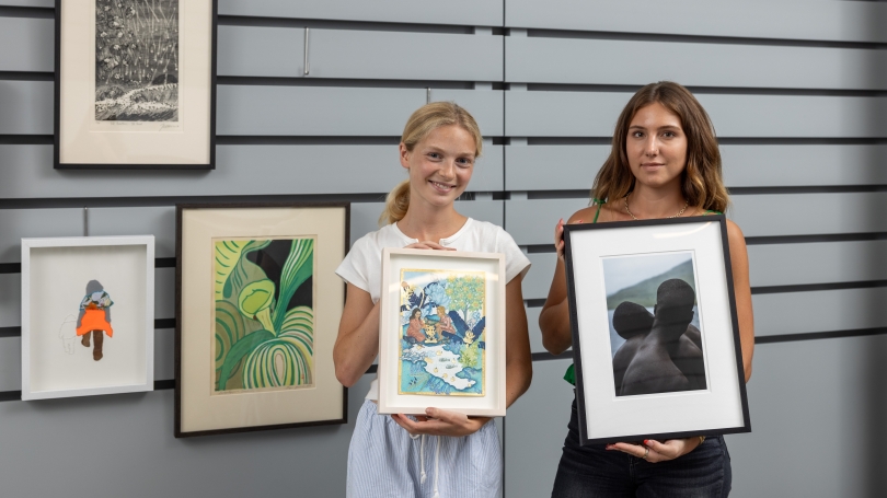 College students browse through artworks on display.