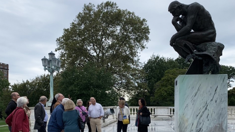 Members of the Director's Circle discussing the historic and cultural significance of Rodin's The Thinker at the Cleveland Museum of Art. 