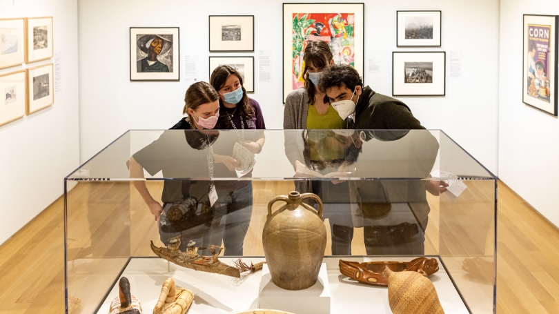 College students explore a museum exhibition of Indigenous, Black, and Euro American art.