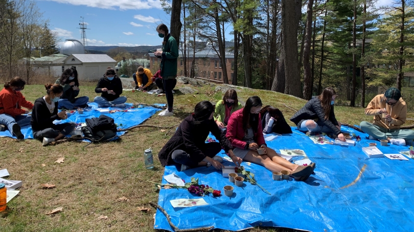 College students outside making art with found objects in nature.