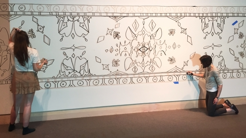 Eva Munday (left) Hood Programming, Class of 1954, Intern created this beautiful design for the Paint-by-Numbers Mural activity. Here Eva and Neely McNulty Hood Images and Art Start Instructor, are drawing Evas design on the gallery walls.