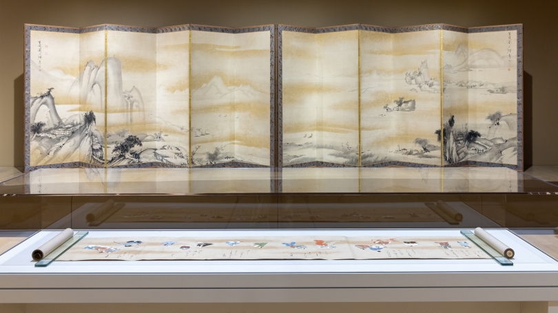 An installation of traditional Japanese art. A 32 foot hand scroll is displayed in the foreground and a large Japanese screen is in the background.