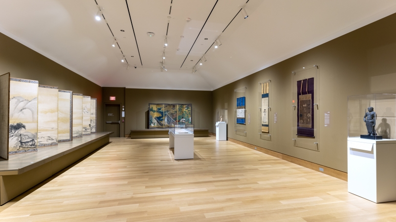 A gallery installed with works of traditional Japanese art. Including hanging scrolls, a hand scroll, and screens.