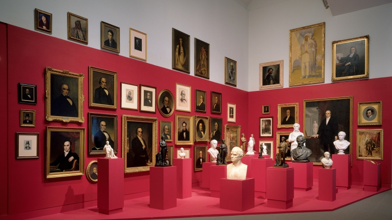 A museum installation of sculptural busts and paintings.