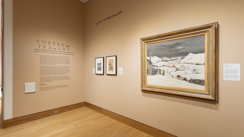 An instillation image of View of "Coffee and Tea in Art: A Brew of Cultural Symbolism, Solace, and Introspection."  The room is painted light brown and has art on the walls.