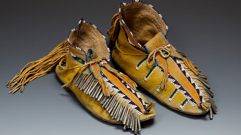 Moccasins made by a Jicarilla Apache artist, about 1900, Native-tanned hide, rawhide, glass beads, tin, ochre, thread. 