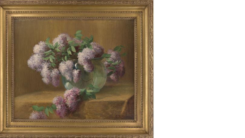 Purple Lilacs sit in a bulbous glass vase