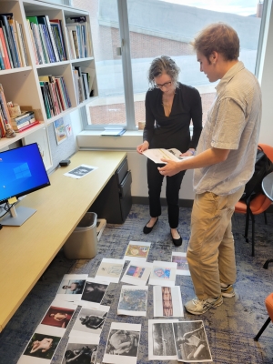 Colin and Neely stand in Neely's office looking over works to include in his Space for Dialogue Exhibition